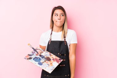 Kafkasyalı genç bir kadın elinde bir palet tutuyor. Kafası karışmış ve kendinden emin değil..