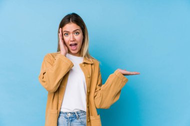 Kafkasyalı genç bir kadın avucunun içinde fotokopi alanı tutuyor, el üstünde tutuyor. Şaşırmış ve mutlu..