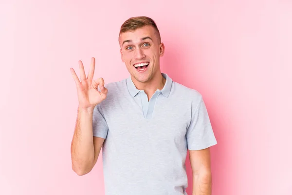 Young Caucasian Man Isolated Winks Eye Holds Okay Gesture Hand — 스톡 사진
