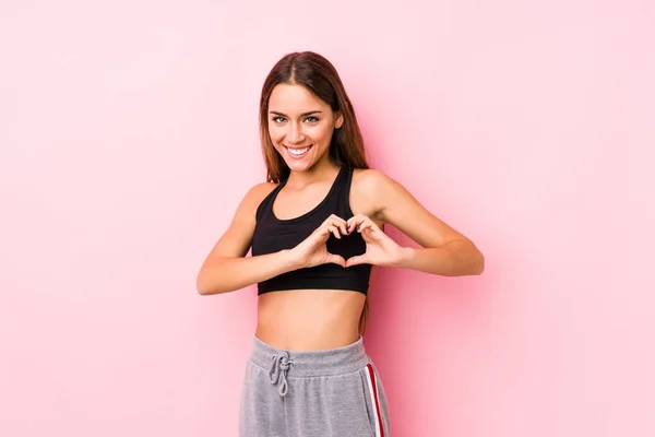 Joven Mujer Fitness Caucásica Posando Fondo Rosa Sonriendo Mostrando Una —  Fotos de Stock