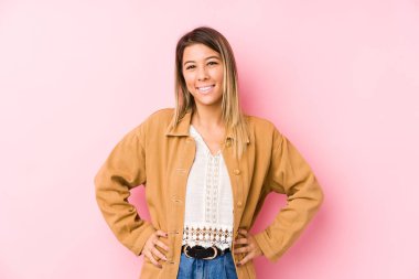 Kafkasyalı genç kadın yalnız poz veriyor. Kendine güveni tam. Kalçalarını tutuyor..