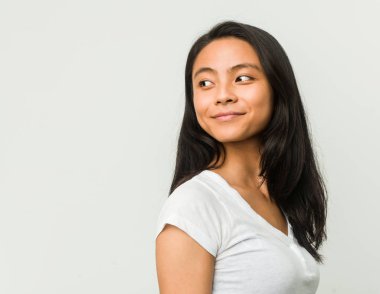 Beyaz arka planda poz veren genç Çinli kadın.