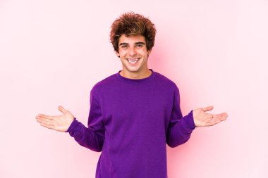 Pembe arka planı olan beyaz bir genç hoş bir yüz ifadesi sergiliyor..