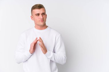 Beyaz arka plandaki genç beyaz adam bir plan yapıyor, bir fikir kuruyor..