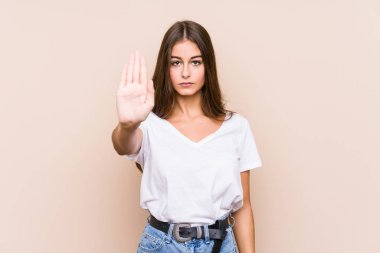 Kafkasyalı genç bir kadın, elini uzatmış yalnız poz veriyor. Dur işareti gösteriyor, bu da seni engelliyor..