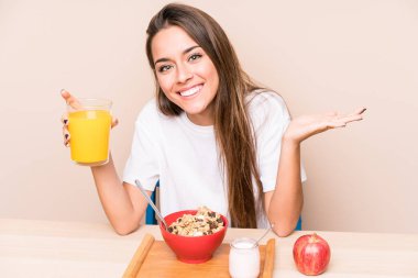 Genç beyaz kadın kahvaltı yapıyor.