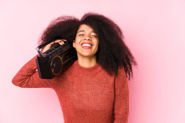 Genç Afro bir kadın elinde kaset tutarak gülüyor ve eğleniyor..