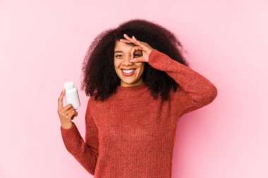 Vitaminlerini tutan genç afro bir kadın vitaminli genç bir afro kadını izole etti..