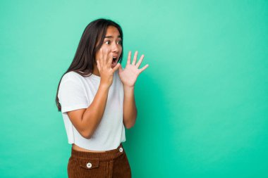 Genç melez Hintli kadın izole edilmiş yüksek sesle bağırıyor, gözleri açık ve elleri gergin tutuyor..