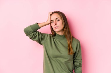 Kafkasyalı genç bir kadın yalnız poz veriyor. Yorgun ve uykulu. Elini başının üstünde tutuyor..