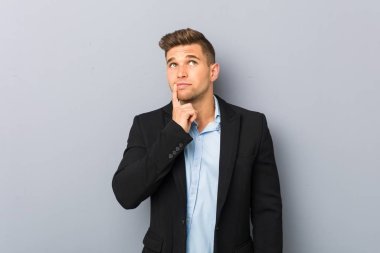 Genç yakışıklı beyaz adam şüpheli ve şüpheci ifade ile yan bakıyor.