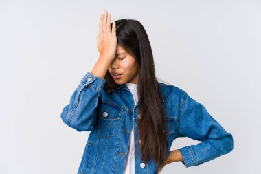 Genç Asyalı bir kadın bir şey unutmuş. Alnına avuç içi ve kapalı gözlerle vuruyor..