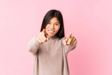 Genç Çinli kadın yalnız poz veriyor. Neşeli gülücükler öne bakıyor..