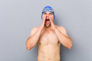 Young professional swimmer man shouting excited to front.