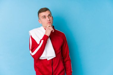 Genç sporcu şüpheli ve şüpheci bir ifadeyle yana bakıyor..