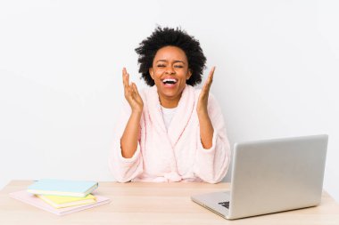 Orta yaşlı Afrikalı Amerikalı kadın evde çalışıyor, neşeli bir şekilde gülüyor. Mutluluk kavramı.