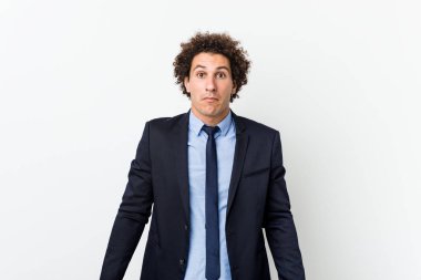 Genç iş adamı beyaz arka plana karşı omuz silker ve gözleri açık kalır..