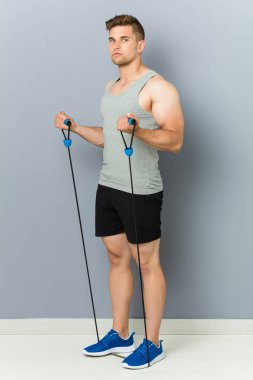 Genç fitness kafkas adam elastik bir bant ile pratik.