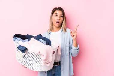 Beyaz tenli genç bir kadın kirli çamaşırlarını toplayıp harika bir fikir üretiyor. Yaratıcılık kavramı..