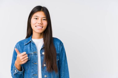 Genç Asyalı kadın gülümsüyor ve başparmağını kaldırıyor.