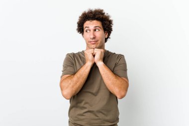 Olgun yakışıklı bir adam yalnız, elleri çenesinin altında, mutlu bir şekilde yan tarafa bakıyor..