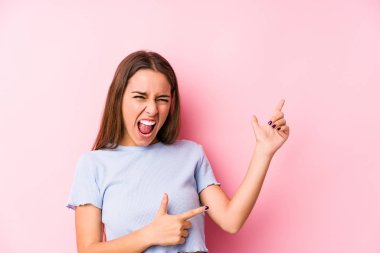 Kafkasyalı genç bir kadın kayak kıyafetleri giyiyor. İzole edilmiş, işaret parmağıyla fotokopi alanını işaret ediyor. Heyecan ve arzu ifade ediyor..