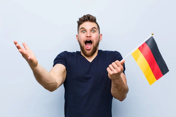 勝利や成功を祝うドイツの旗を持っている若い白人男性 — ストック写真