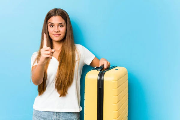 Joven Mujer Caucásica Sosteniendo Una Maleta Viaje Mostrando Número Uno —  Fotos de Stock