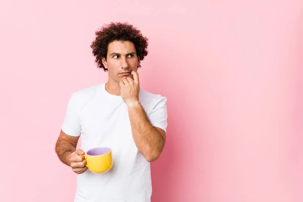 Young Caucasian Curly Man Holding Tea Cup Relaxed Thinking Something — 스톡 사진