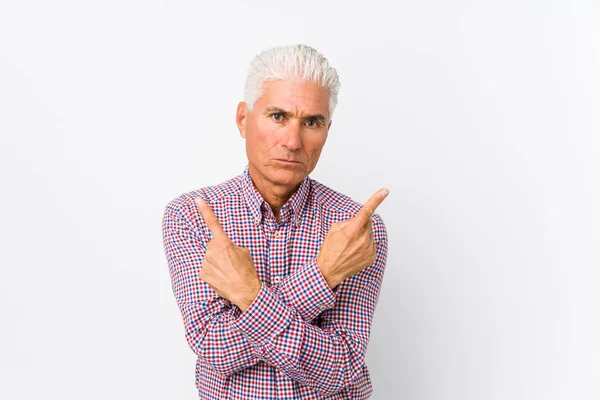 Senior Caucasian Man Isolated Points Sideways Trying Choose Two Options — Stock Photo, Image