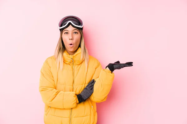 Young Caucasian Woman Wearing Ski Clothes Pink Background Impressed Holding — 스톡 사진