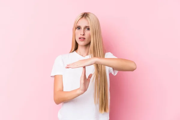 粉红背景的年轻金发女子表现出暂停的姿态 — 图库照片