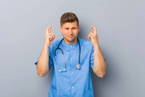 Mladý Ošetřovatel Muž Držící Palce Pro Štěstí — Stock fotografie