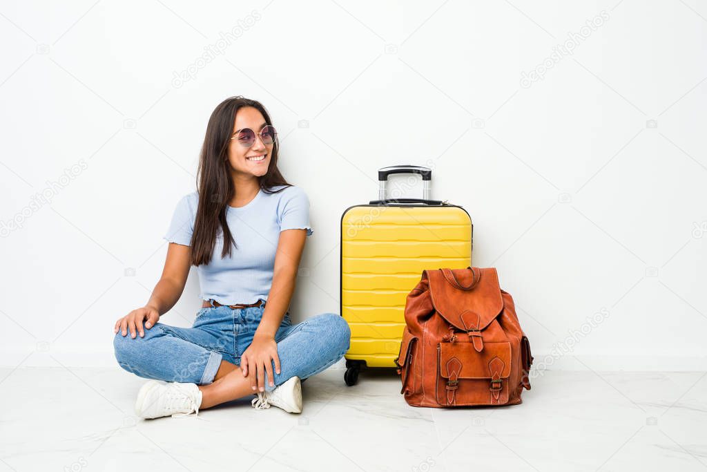 Young mixed race indian woman ready to go to travel looks aside smiling, cheerful and pleasant.