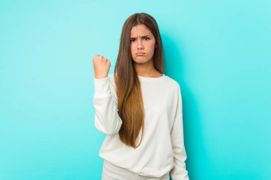 Genç zayıf kadın kameraya yumruğunu gösteriyor, agresif yüz ifadesi..