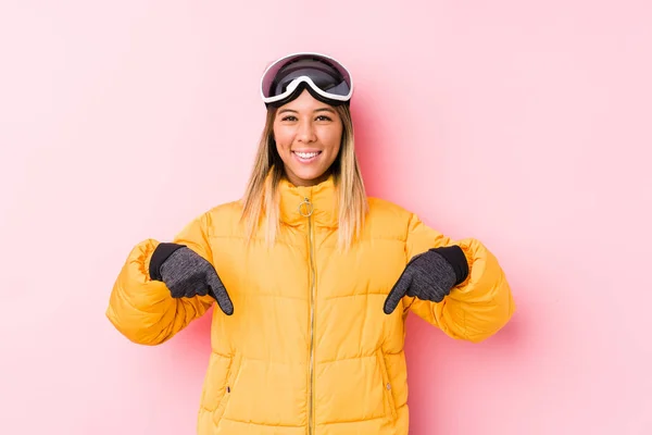 Mulher Branca Jovem Vestindo Uma Roupa Esqui Fundo Rosa Aponta — Fotografia de Stock