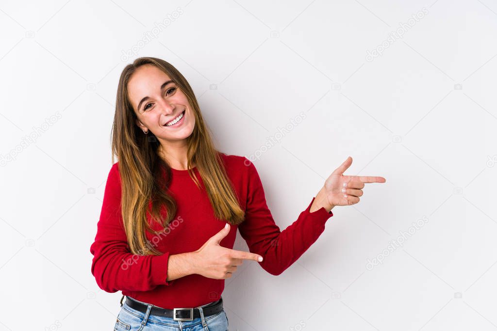 Young caucasian woman posing isolated  excited pointing with forefingers away.
