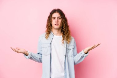 Uzun saçlı adam yalnız poz veriyor. Hoş bir yüz ifadesi sergiliyor..