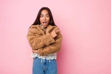 Yan tarafı gösteren kısa bir koyun derisi giyen genç Hintli kadın.