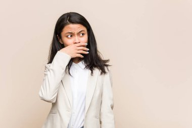 Genç iş kadını Çinli düşünceli. Fotokopi odasına bakıyor. Ağzını eliyle kapatıyor..