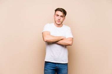Young caucasian man posing isolated frowning face in displeasure, keeps arms folded. clipart