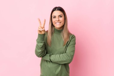 İki numarayı parmaklarıyla gösteren yalnız beyaz bir kadın..