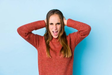 Kafkasyalı genç bir kadın yalnız poz veriyor. Kulaklarını elleriyle kapatıyor. Gürültülü sesler duymamaya çalışıyor..