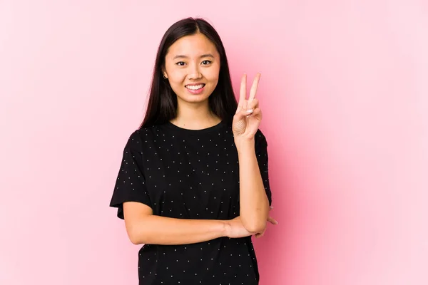 年轻的亚洲女人穿着雅致的衣服 隔离着 用手指展示着二号 — 图库照片