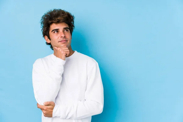 Young Caucasian Man Blue Background Isolated Looking Sideways Doubtful Skeptical — 스톡 사진