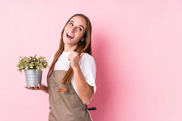 Young Gardener Caucasian Woman Isolated Points Thumb Finger Away Laughing — Stock Photo, Image