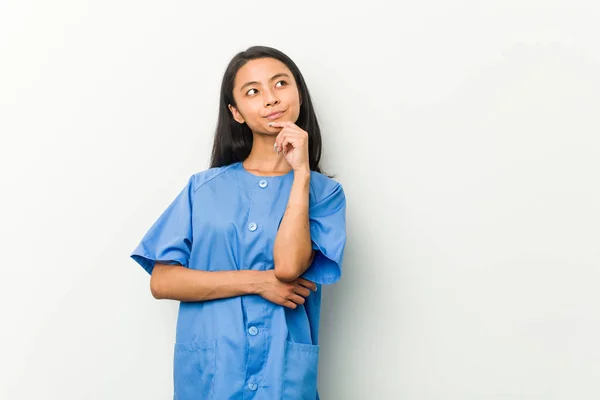 Young Asian Nurse Woman Looking Sideways Doubtful Skeptical Expression — 스톡 사진