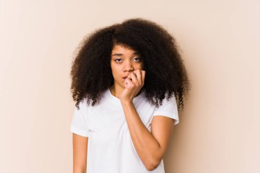 Young african american woman biting fingernails, nervous and very anxious.