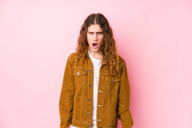 Uzun saçlı genç adam yalnız poz veriyor. Çığlıklar atıyor. Çok sinirli ve agresif..