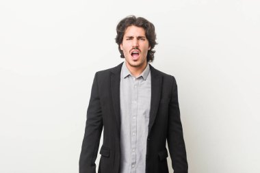 Beyaz arka planda genç bir iş adamı çok sinirli ve agresif bağırıyor..